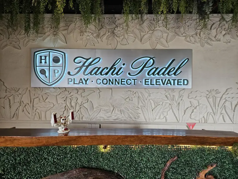 The Hachi Padel reception with carved wall and greenery