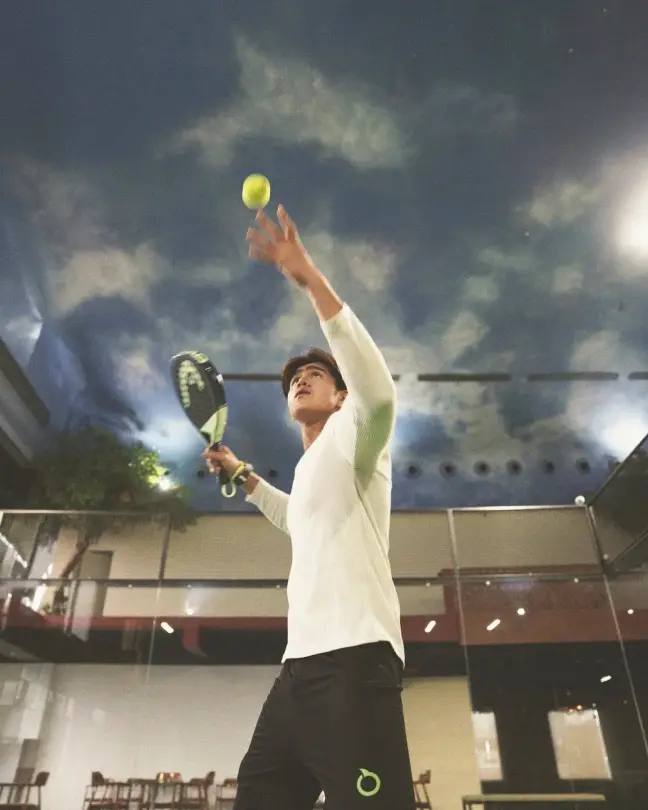 A player serving under the painted sky